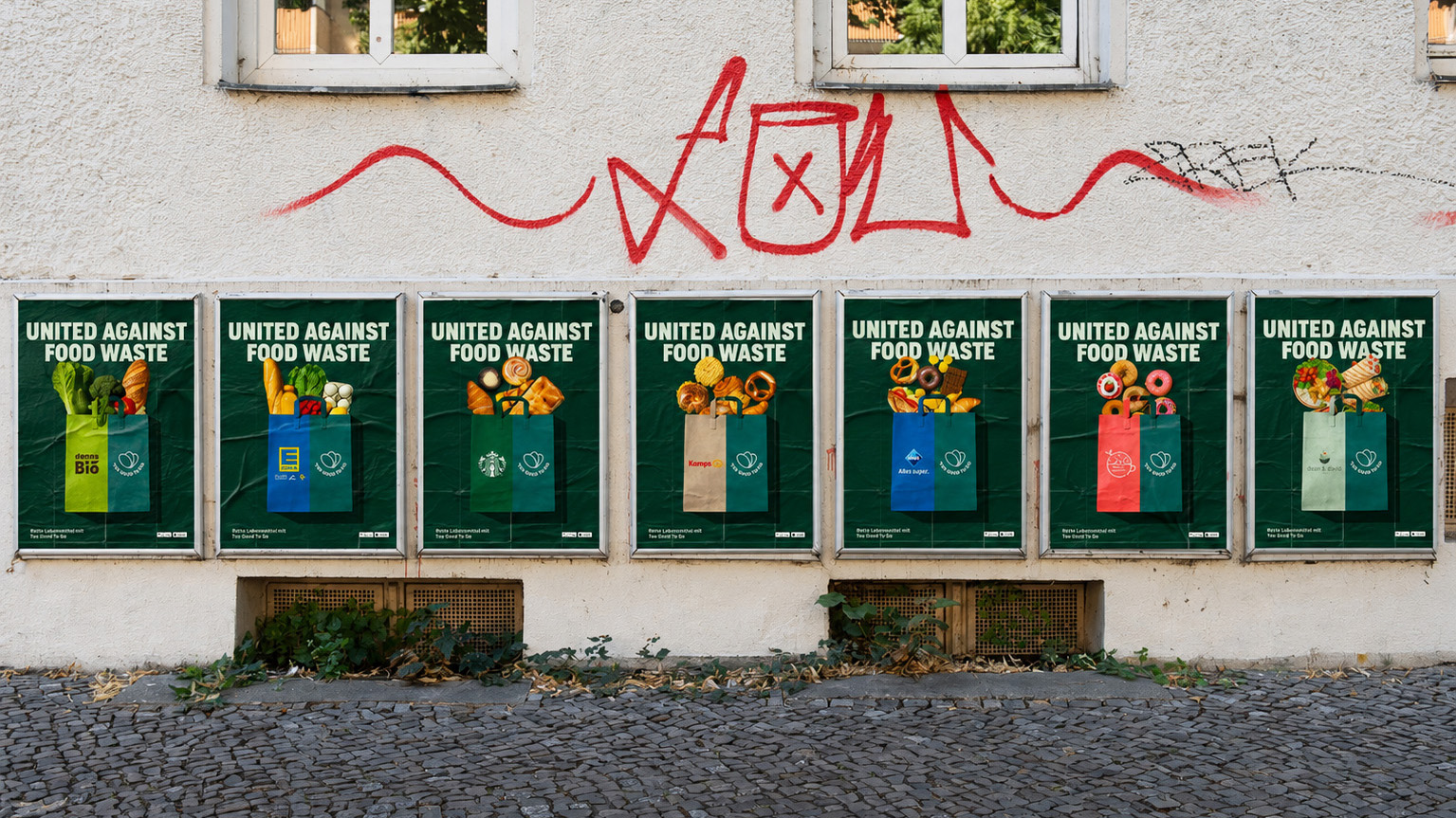 Seven 'United Against Food Waste' posters in a row on a graffitied street wall, each with a different partner brand